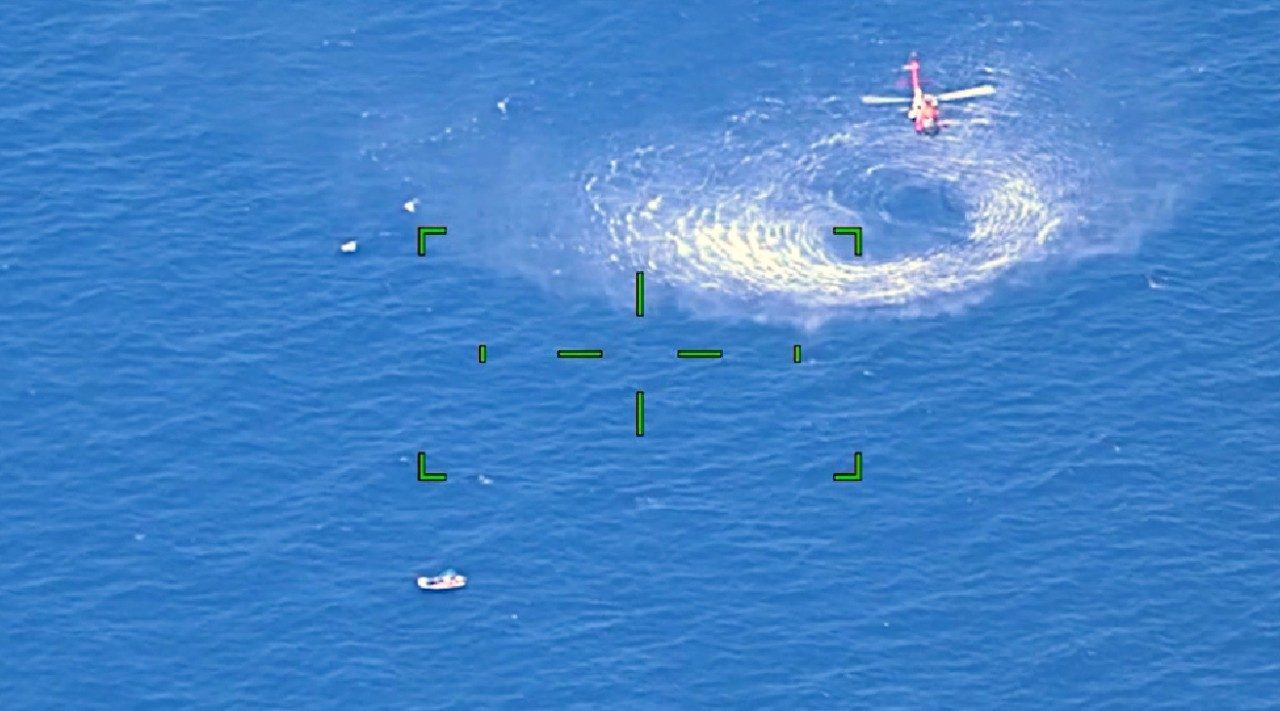 The MH-60T Jayhawk hovers near the disabled vessel on May 20 to release the rescue swimmer into the water and hoist the boaters to safety. (Photo courtesy U.S. Coast Guard District 7).